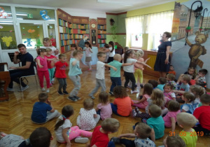 Dzieci tańczą po kole.